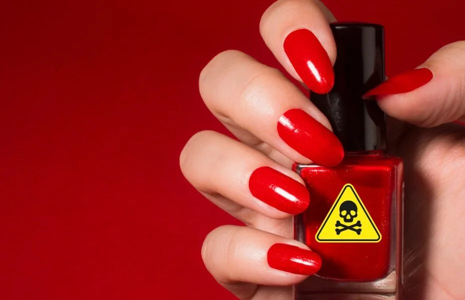 mão com unha pintada segurando um frasco de esmalte